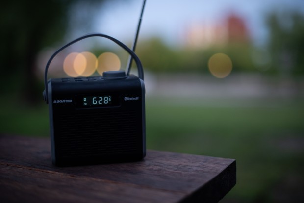 Petite radio portable déposé sur un banc à l'extérieur.